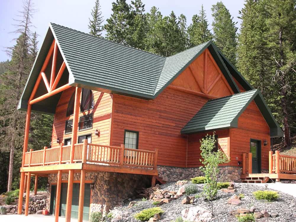 Green metal roof compliments the wood on a redwood mountain style home.
