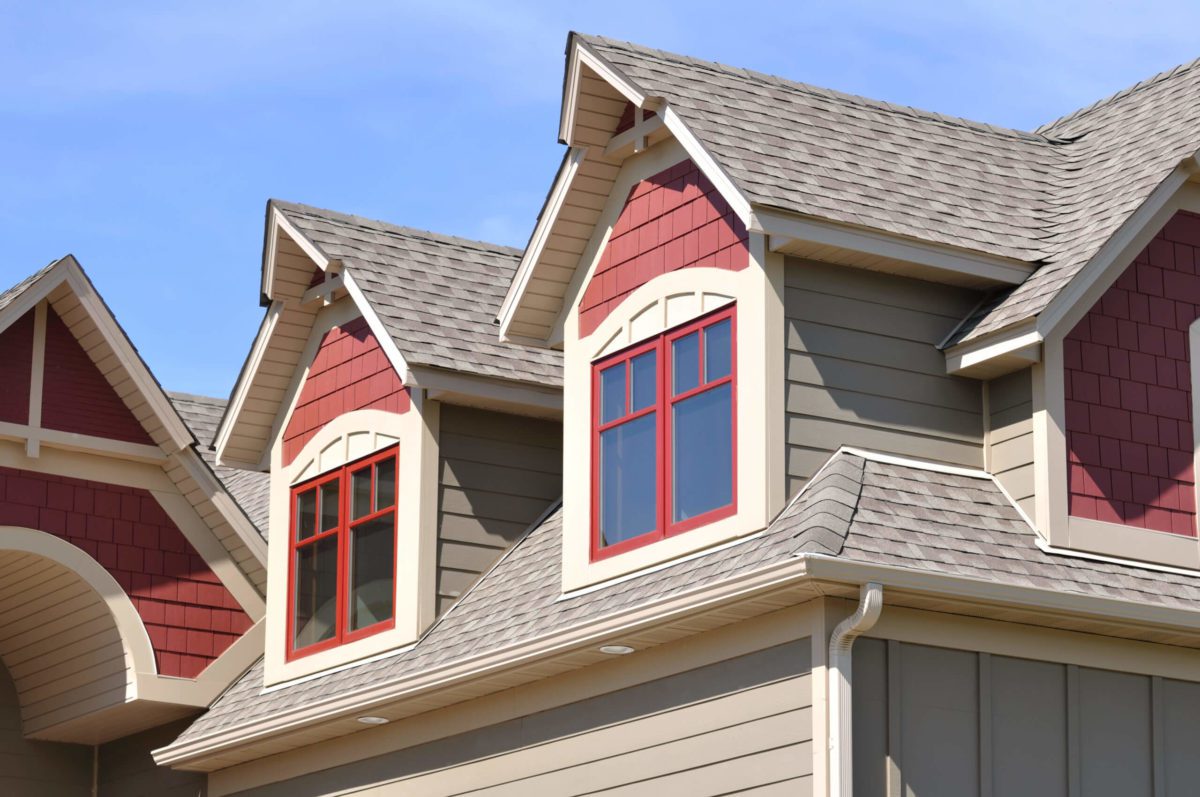 Red and tan siding panels, with brown and tan roof shingles