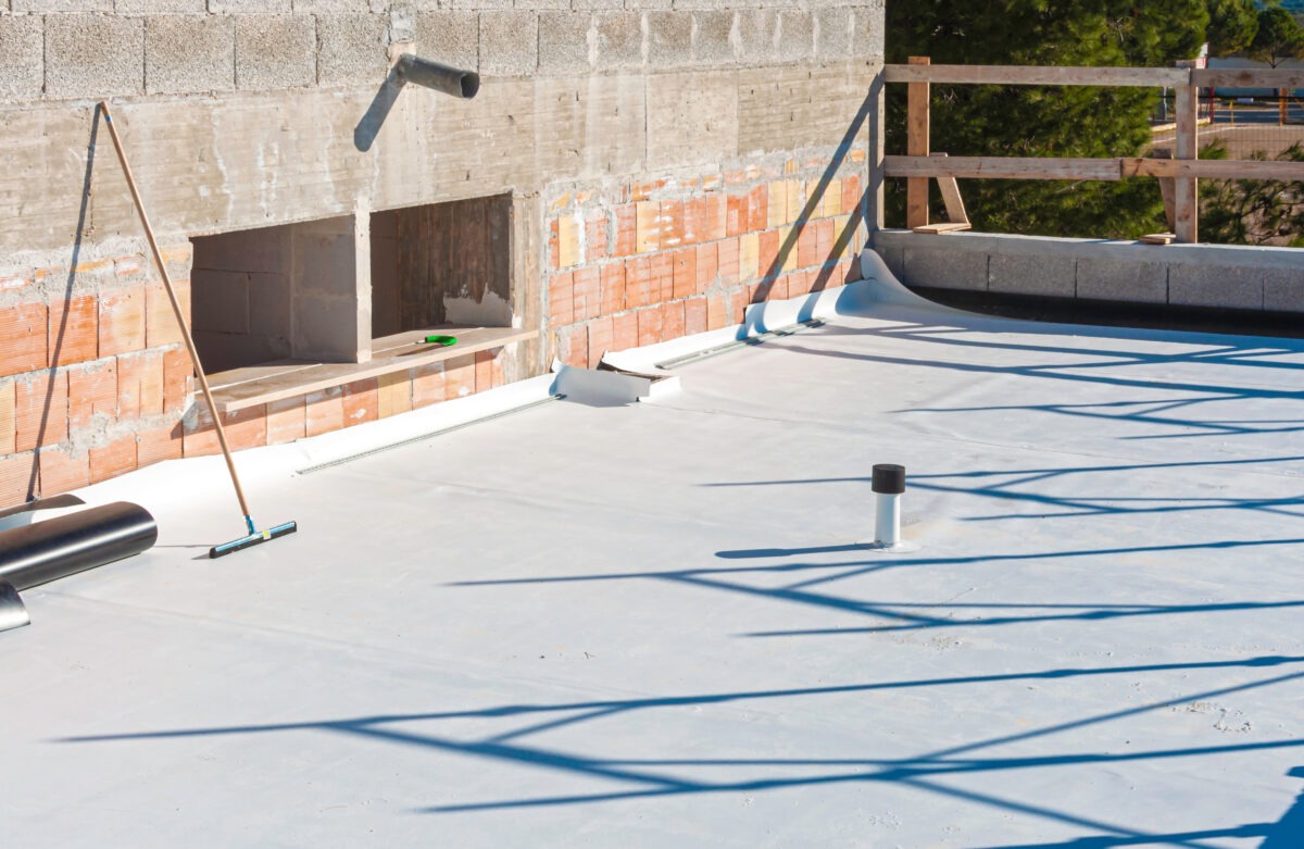 Worker applies TPO roofing on roof