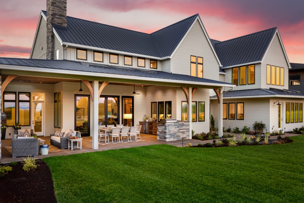 exterior of a beautiful luxury home with a covered patio attached to house sunset in background