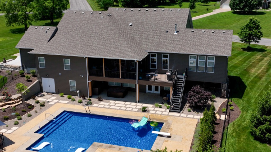 backyard view of home with a swimming pool and timbertech decking